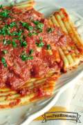 Plato de pasta rellena de queso con salsa roja y perejil fresco.